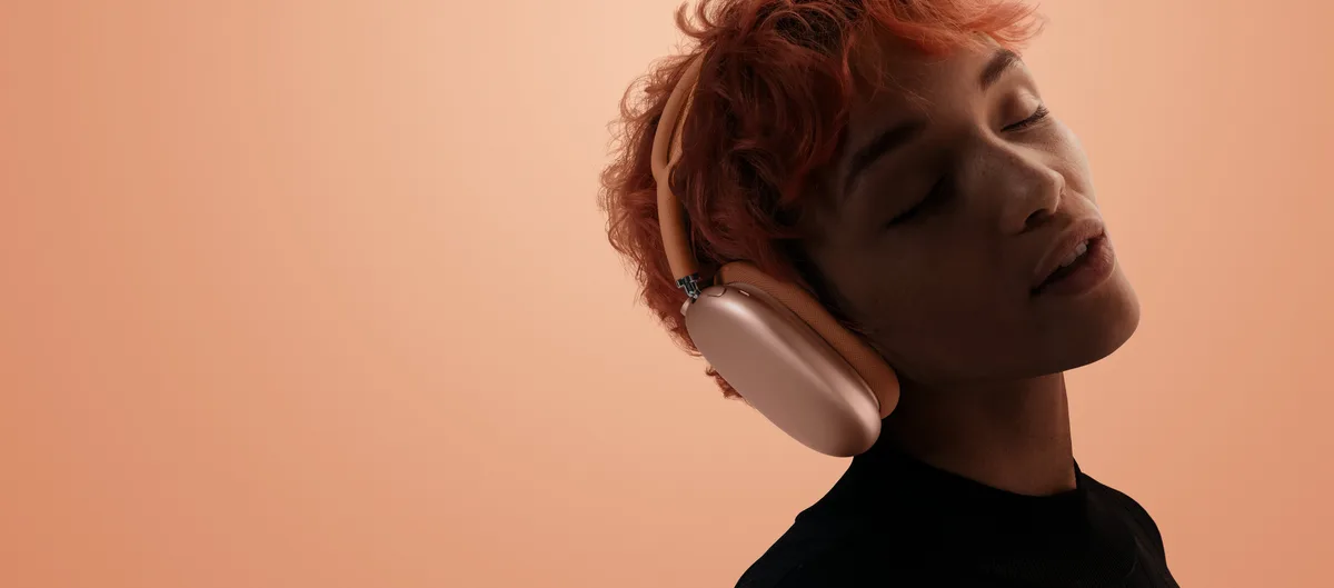 Woman wearing AirPods Max 2 in orange, listening to Hi-Fi audio
