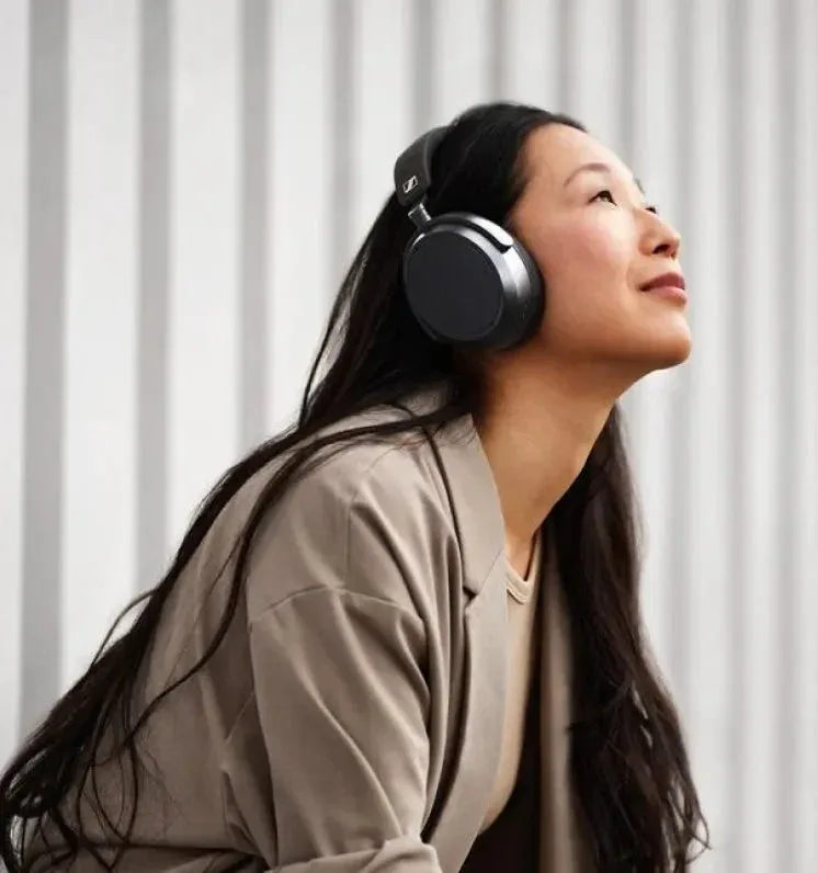 Woman wearing Sennheiser Momentum 4 outdoors in urban setting