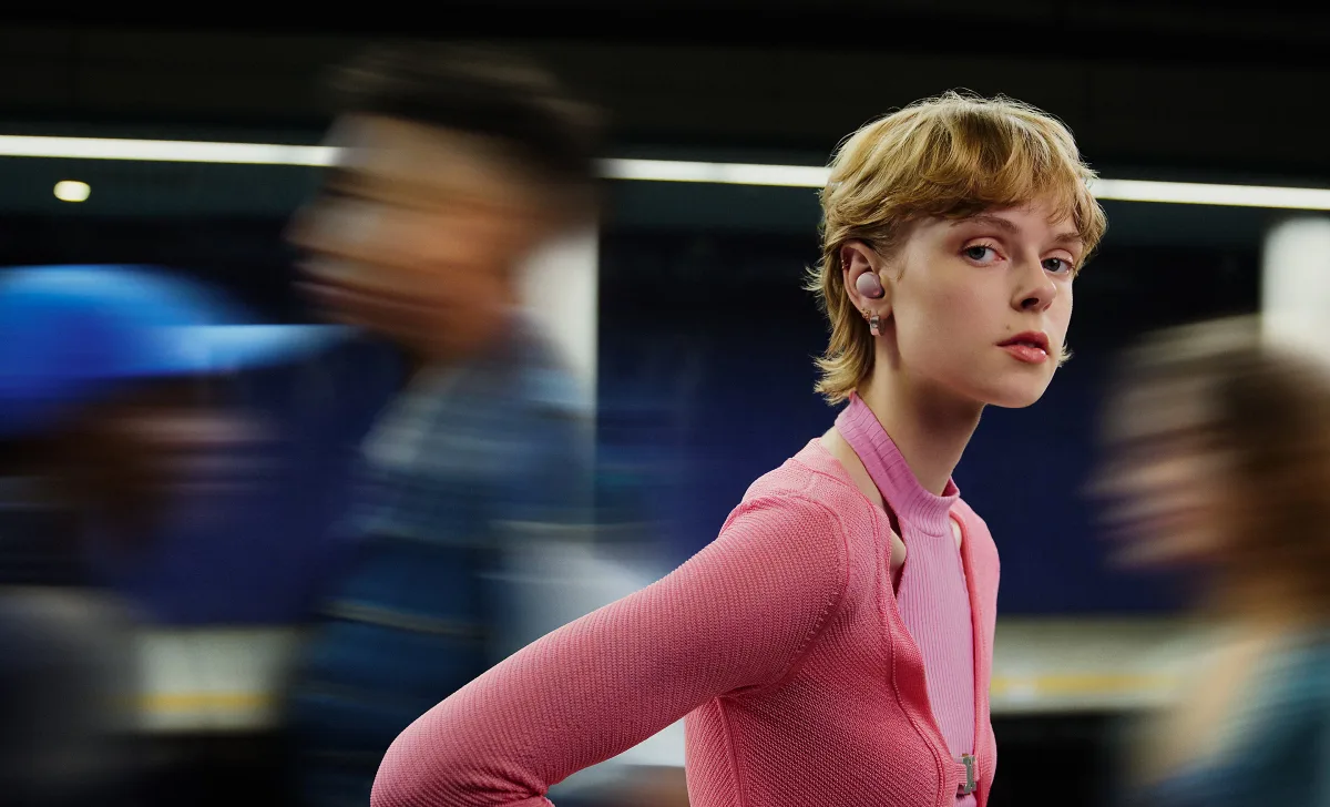 Woman wearing Sony WF-1000XM5 in train station